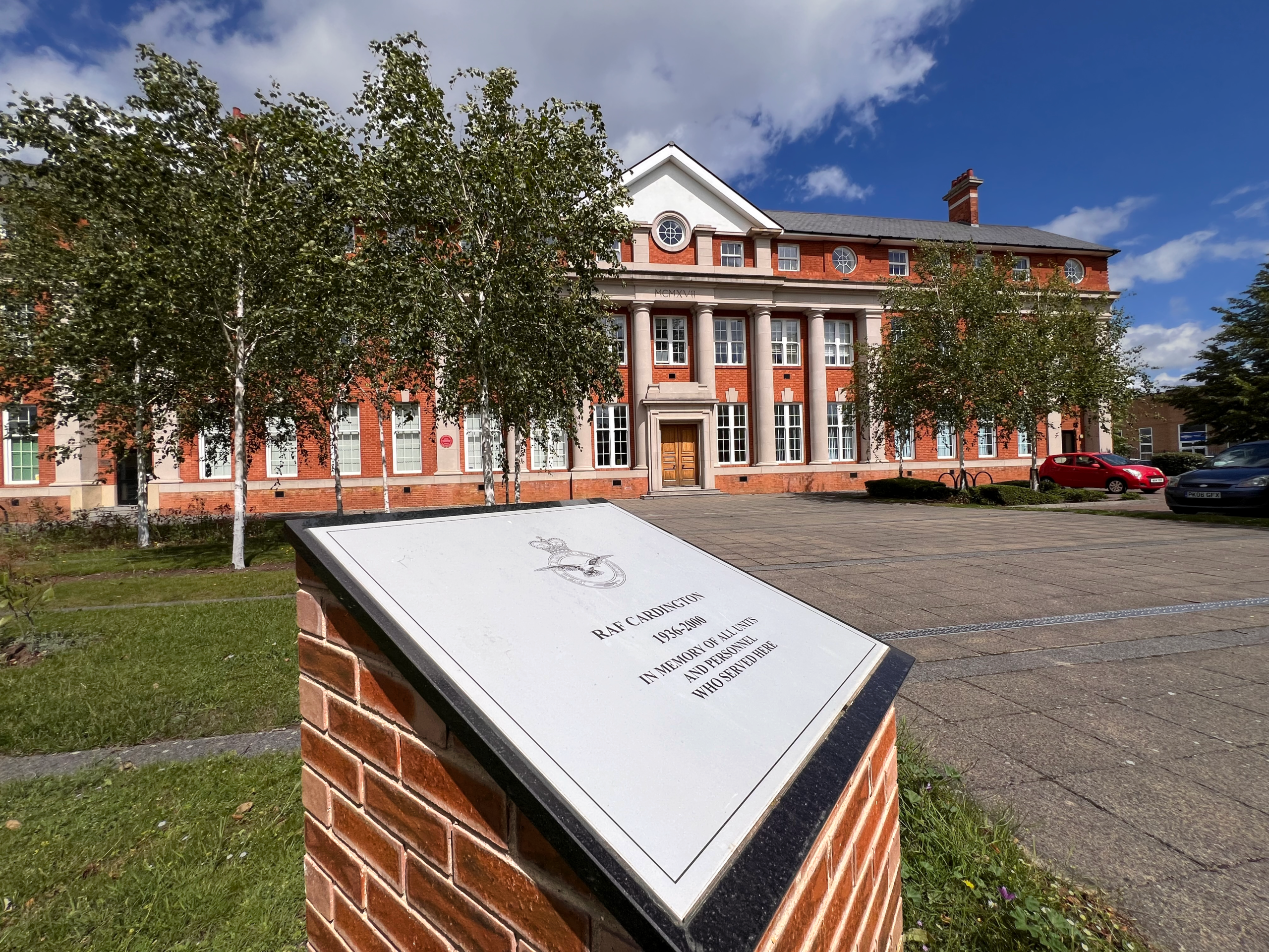 The RAF Cardington memorial stone on a brick plinth in front of the Shorts Building, inscribed in memory of all units and personnel who served there from 1936 to 2000